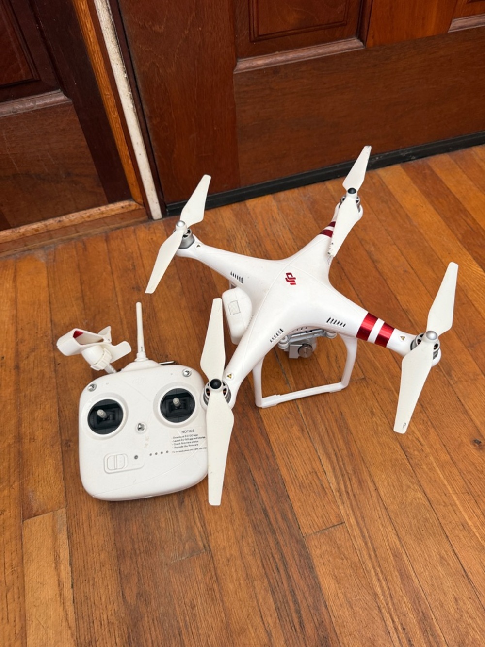 DJI white quadcopter drone with red accent stripes and white controller